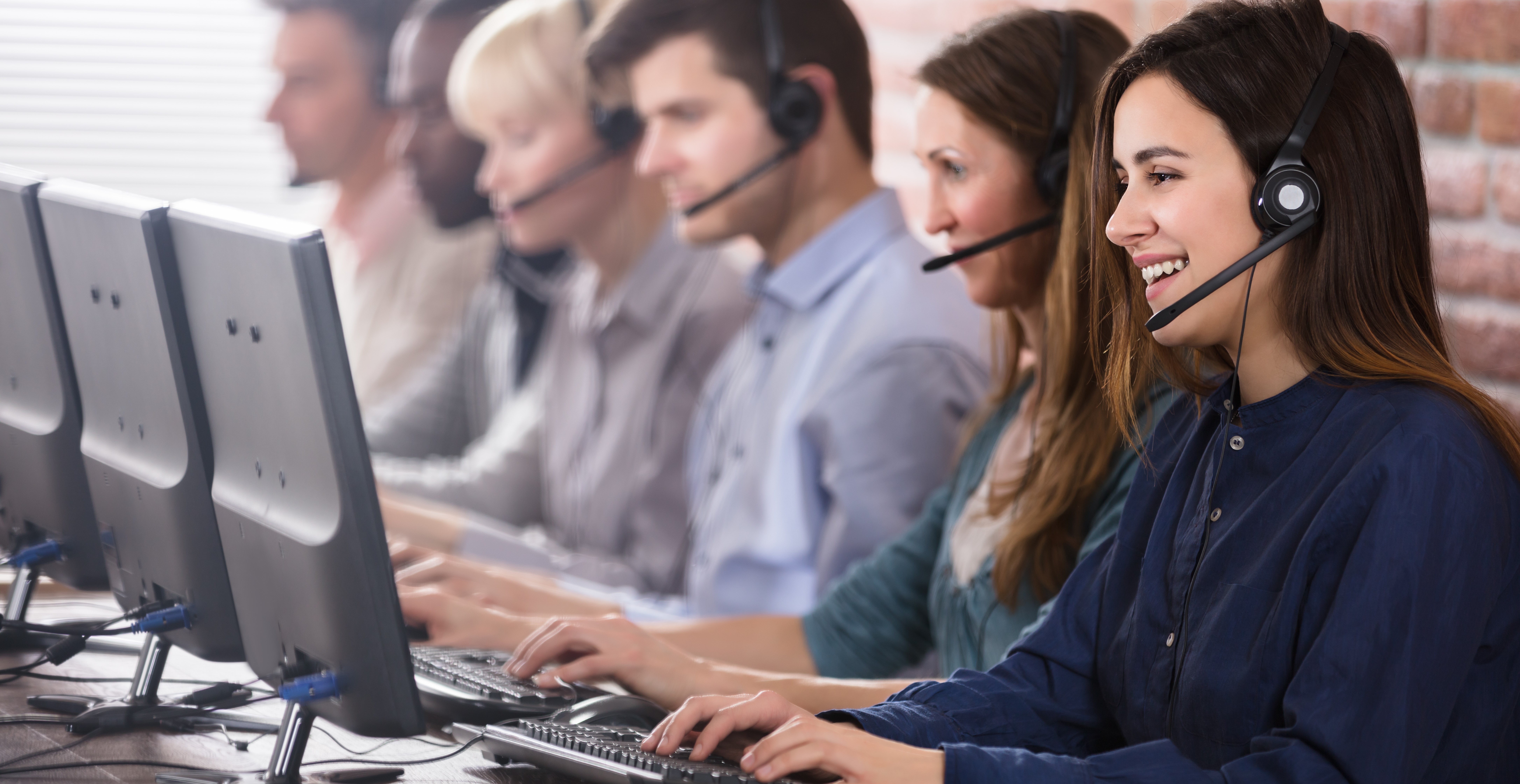 Contact Centre agents on headphones talking to clients