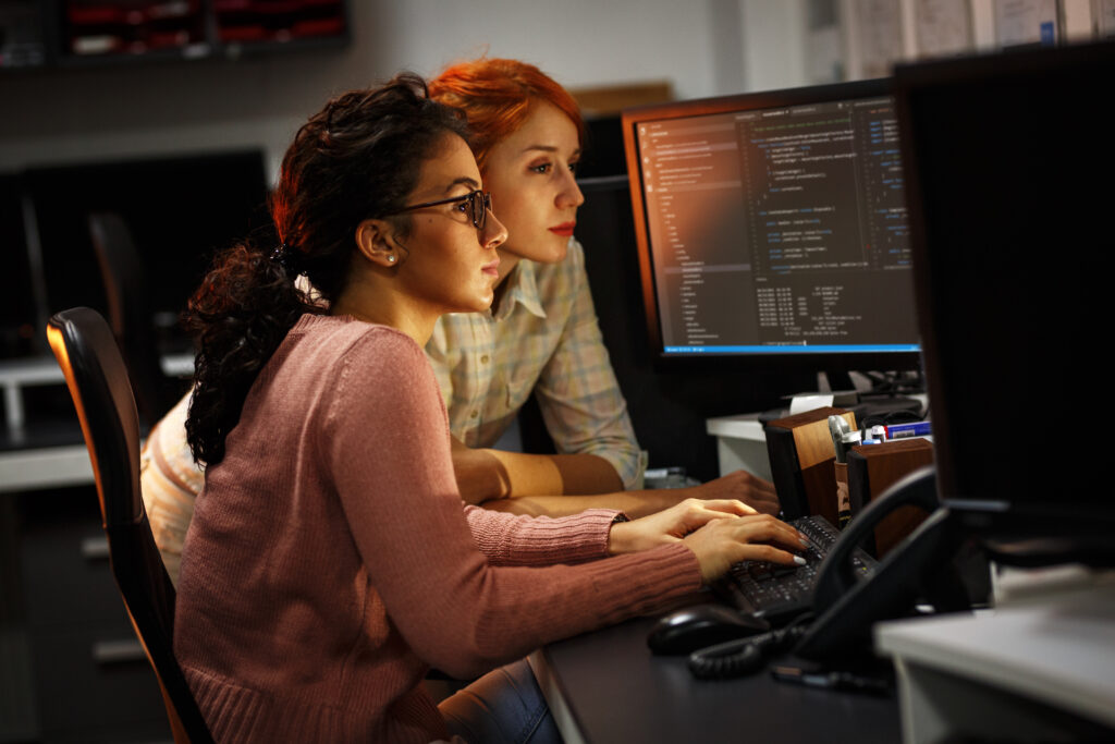 Two female developers in front of screens